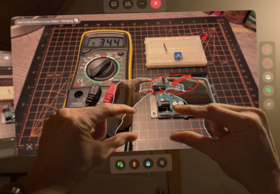 Merged Reality on Vision Pro. Ghost hands and a red annotation sit on a live view of a bench.